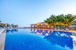 a large swimming pool in front of a building at Cinarli Kasri in Gokceada Town