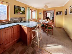 a kitchen and dining room with a table and chairs at Nether Carness in North Ballachulish