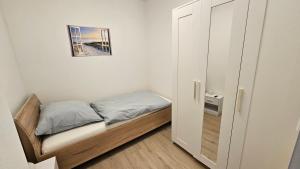 a small bedroom with a bed and a cabinet at Schönes Apartment in Verl in Verl