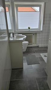 a bathroom with a sink and a toilet and a window at Schönes Apartment in Verl in Verl +2 photos