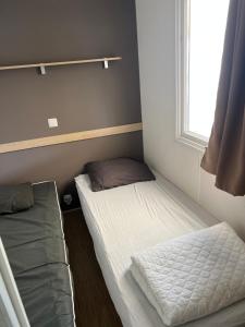 two beds in a small room with a window at Mobilehome in Vias +11 photos