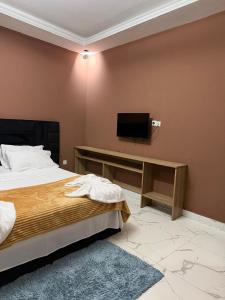 a bedroom with a bed and a flat screen tv at Residencial Convênios- Hotelaria e Turismo LDA in Luanda
