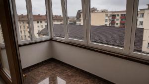 a room with four windows with a view of a city at Apartament Central in Moineşti