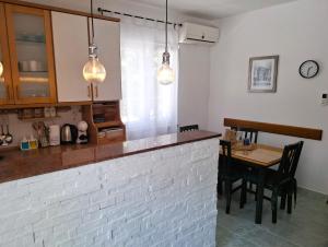 a kitchen with a brick counter and a table at Vecky in Jezera