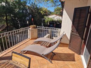 two white chairs sitting on a deck with a gate at Villa Mala in Zavala
