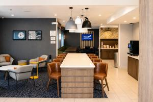 a bar in a waiting room with chairs at City Express by Marriott Lafayette in Lafayette