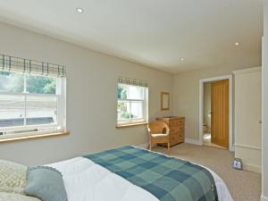 a bedroom with a bed and a desk and two windows at Eddystone Row 2 in Salcombe