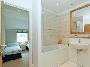 a bathroom with a bath tub and a sink at Eddystone Row 2 in Salcombe