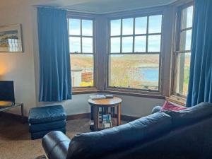 a living room with a couch and two large windows at Plover Apartment - Uk51129 in Carradale