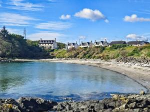 a view of a beach with houses in the background at Plover Apartment - Uk51129 in Carradale