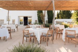 a restaurant with white tables and chairs under a tent at Torralbenc, a Small Luxury Hotel of the World in Cala en Porter