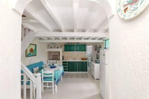 a kitchen with green cabinets and a table and a refrigerator at Villa Potami in Agnontas