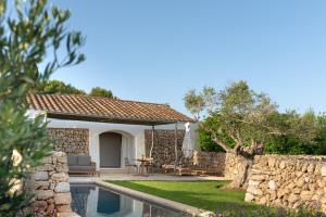 a villa with a swimming pool and a patio at Torralbenc, a Small Luxury Hotel of the World in Cala en Porter