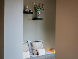 a room with a couch with a vase of flowers on the wall at Tip !!! Appartementen Leonardus in Valkenburg