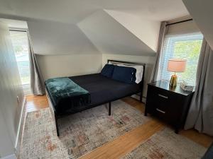 a small bedroom with a bed and a table at Oakland Beach Cottage - Sleeps up to 4 in Warwick