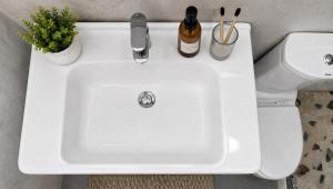 a white sink in a bathroom next to a toilet at Villa Nathanael in Pogradec +29 photos