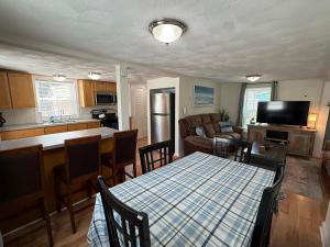 a kitchen and living room with a table and chairs at Oakland Beach Cottage - Sleeps up to 4 in Warwick
