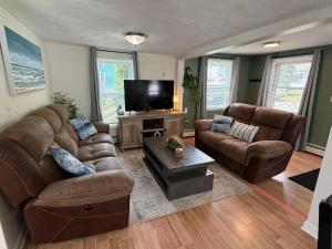 a living room with two couches and a flat screen tv at Oakland Beach Cottage - Sleeps up to 4 in Warwick