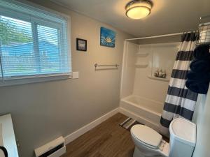 a bathroom with a toilet and a bath tub at Oakland Beach Cottage - Sleeps up to 4 in Warwick +23 photos