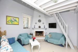a living room with two blue chairs and a fireplace at Villa Potami in Agnontas