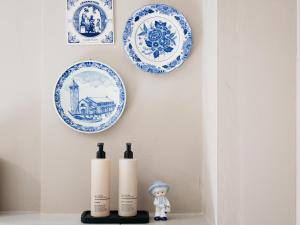 a shelf with three blue and white plates on a wall at Tip !!! Appartementen Leonardus in Valkenburg