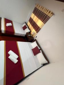 two twin beds in a room with at The Red Loft Mihinthale in Anuradhapura +15 photos