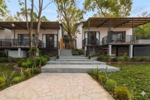 a house with stairs and trees in front of it at Golden Hill Villas Phu Quoc in Phú Quốc