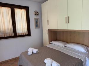 a bedroom with a bed with towels on it at Villa Egusa in Favignana