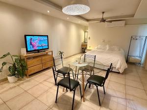 a bedroom with a bed and a table and chairs at Verde Limon Loft (monoambiente) in San Salvador de Jujuy