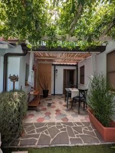 a patio with a table and chairs under a pergola at La casa del glicine Marrubiu in Marrùbiu