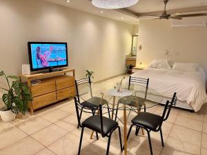 a bedroom with a bed and a glass table and chairs at Verde Limon Loft (monoambiente) in San Salvador de Jujuy