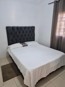 a bed with a black headboard in a room at Avery's Cottage in Livingstone