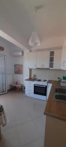 a kitchen with white cabinets and a stove top oven at Kate House in Agioi Apostoli