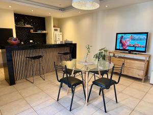 a dining room with a table and chairs and a tv at Verde Limon Loft (monoambiente) in San Salvador de Jujuy