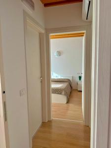 a hallway with a bed in a white room at Ca' Luciana Valdobbiadene in Valdobbiadene +10 photos