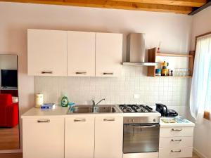 a kitchen with white cabinets and a sink at Ca' Luciana Valdobbiadene in Valdobbiadene