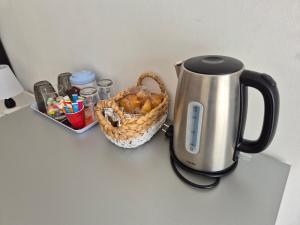 a coffee maker and a basket of food on a counter at Les Lauriers in Espondeilhan