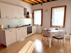 a kitchen with a table and chairs in a kitchen at Ca' Luciana Valdobbiadene in Valdobbiadene
