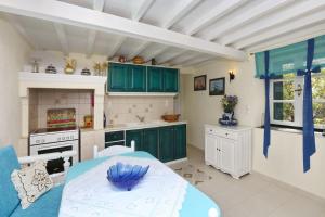 a kitchen with green cabinets and a table in a room at Villa Potami in Agnontas +33 photos
