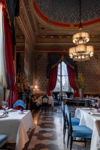 a dining room with two tables and a chandelier at Villa Cora in Florence