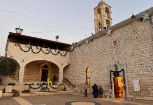 a large brick building with a clock tower at Quiet Corner in Mafshatah