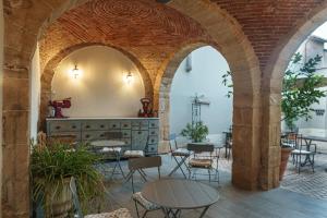 an archway with tables and chairs in a restaurant at Dimora Ferraris in Càbras