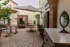 a patio with a table and chairs and an umbrella at Dimora Ferraris in Càbras