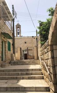 an old stone building with stairs and a clock tower at Quiet Corner in Mafshatah