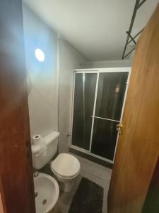 a bathroom with a white toilet and a window at Hospedaje La Trinidad in Junín +5 photos