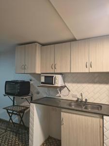 a kitchen with a sink and a microwave at Hospedaje La Trinidad in Junín