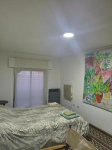 a bedroom with a bed and a painting on the wall at Hospedaje La Trinidad in Junín
