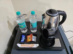 a tray with a tea kettle and two bottles of water at Hotel Ashok Residency, Porur in Chennai