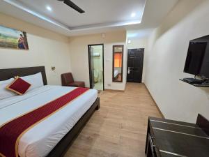 a hotel room with a bed and a television at Hotel Ashok Residency, Porur in Chennai +44 photos