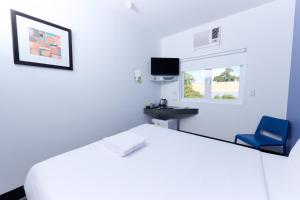 a waiting room with a blue chair and a window at ibis Budget Perth Airport in Perth +15 photos